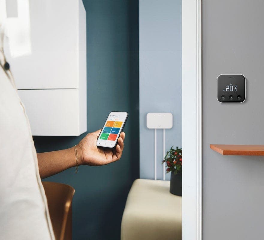 Slimme thermostaat wordt bediend met een telefoon naast de cv-ketel